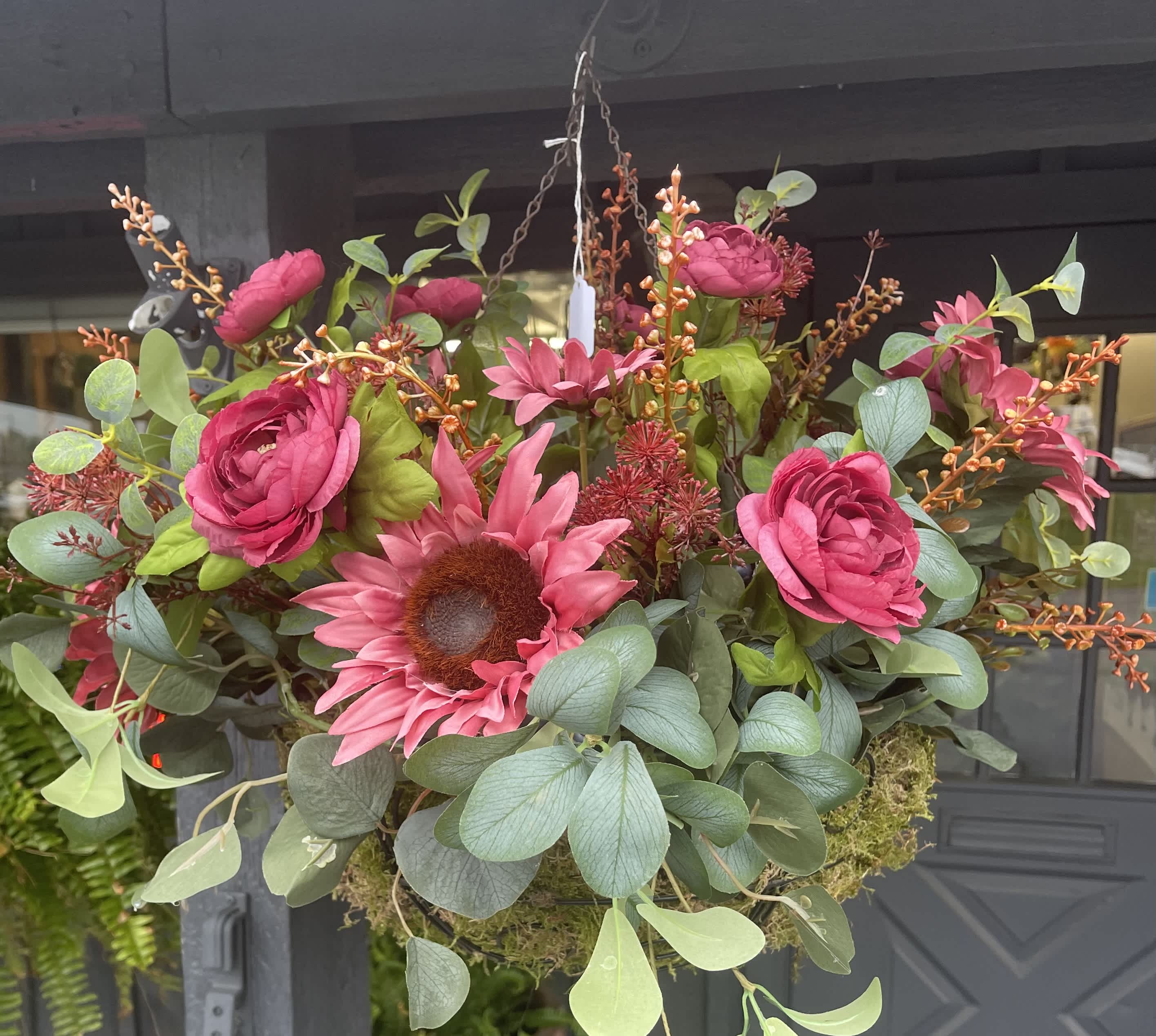 Hanging floral basket with bright pink blooms and eucalyptus