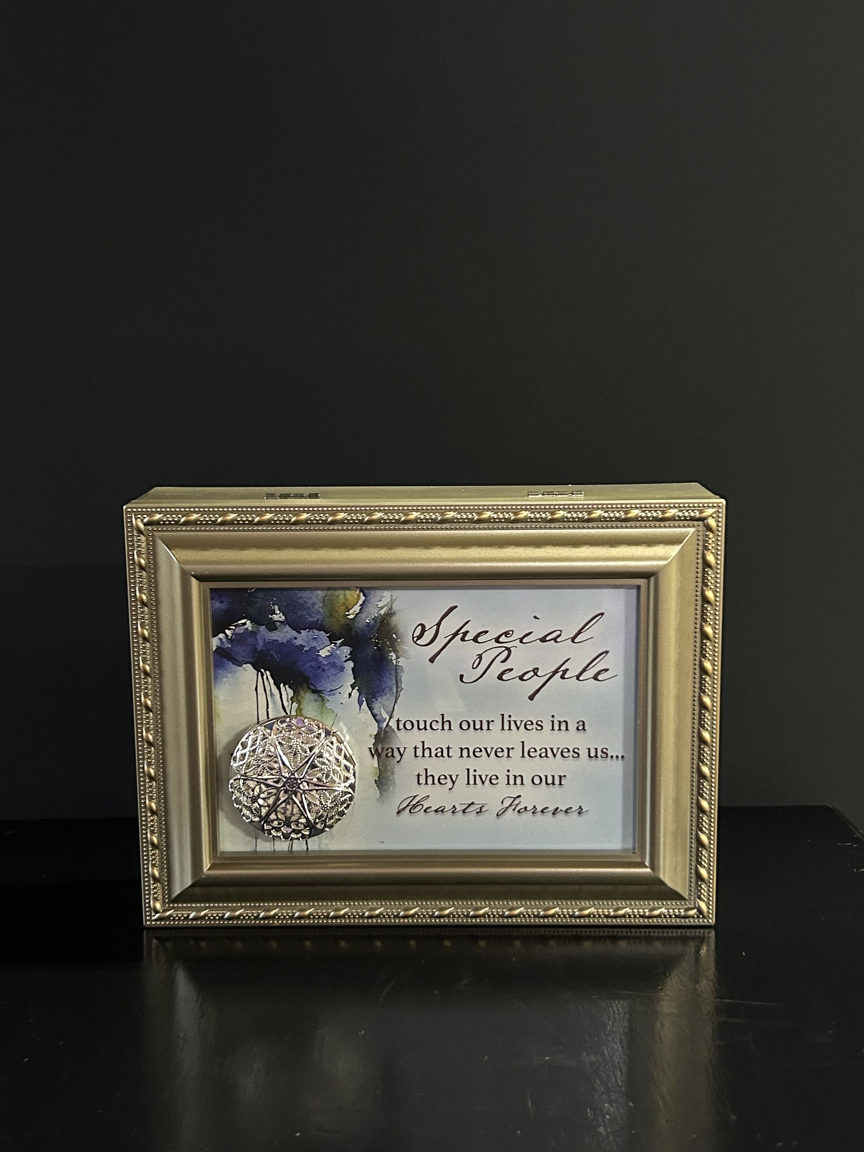Framed memorial plaque with a decorative medallion and condolence message