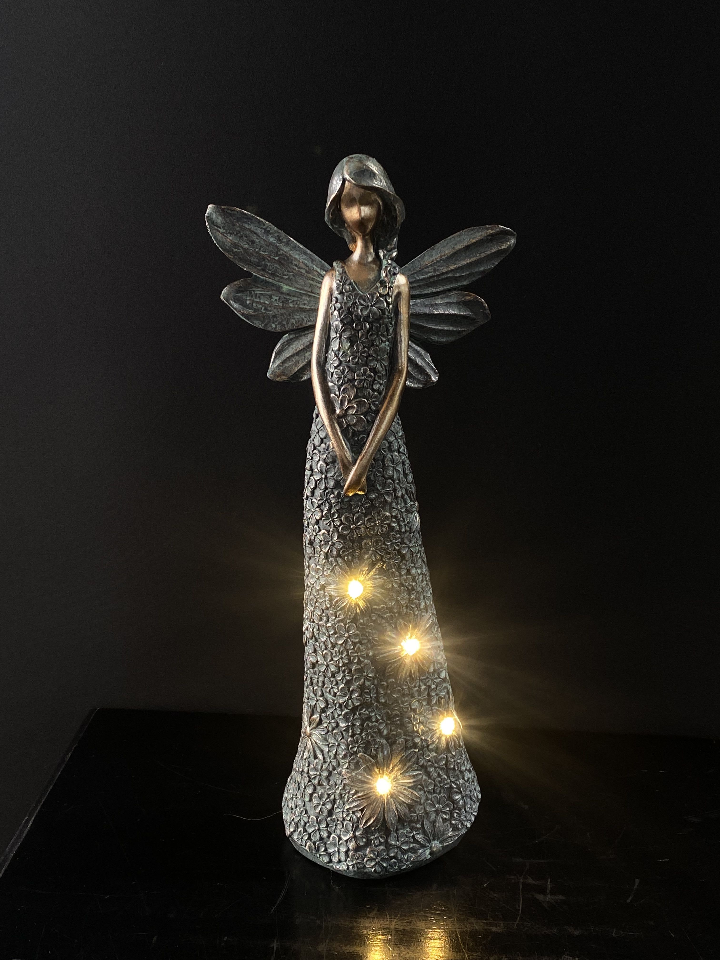 Decorative angel figurine with glowing lights on a dark background