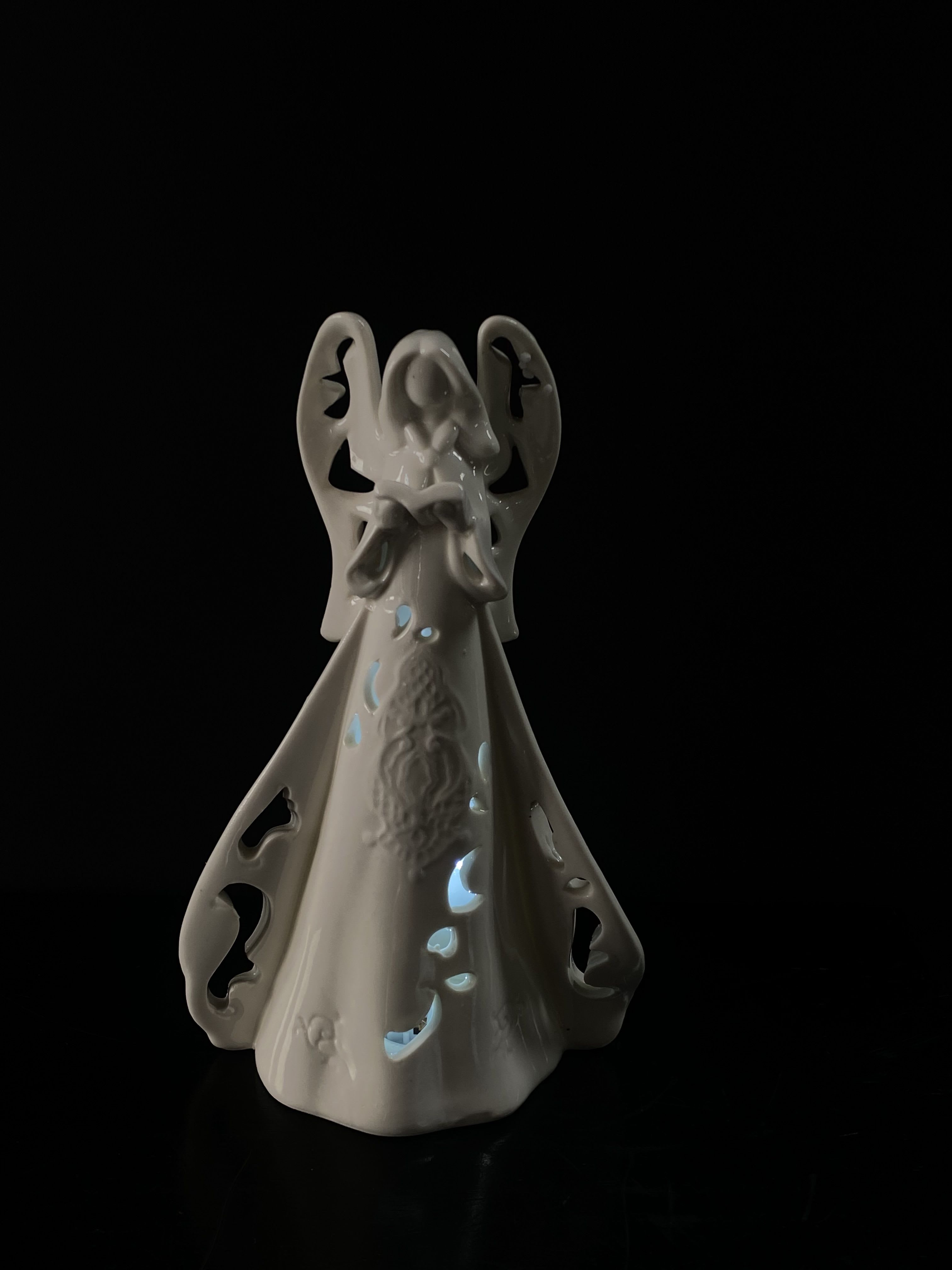 White ceramic angel figurine with cutout details