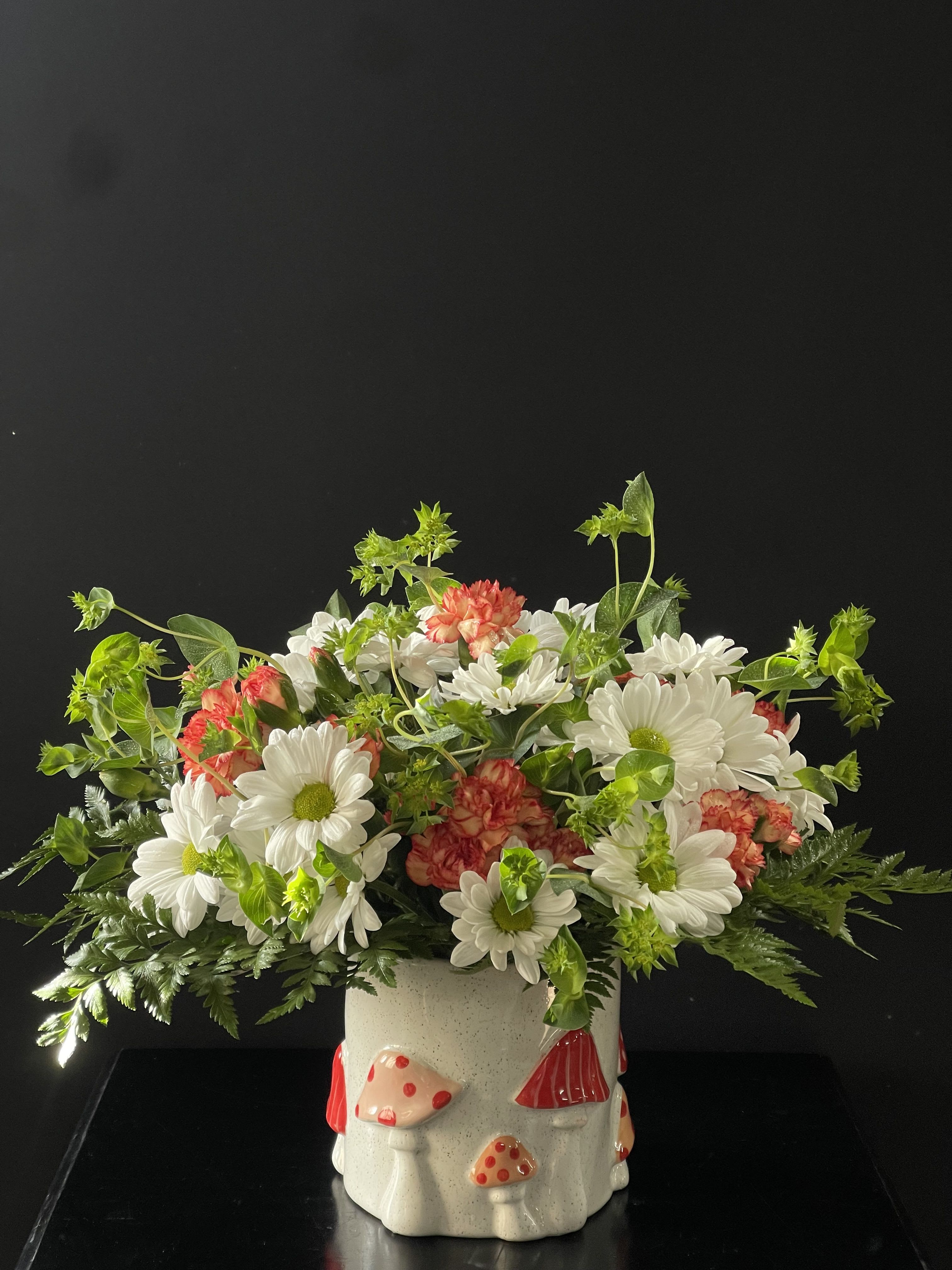 White daisies and pink carnations in a mushroom-decorated ceramic pot