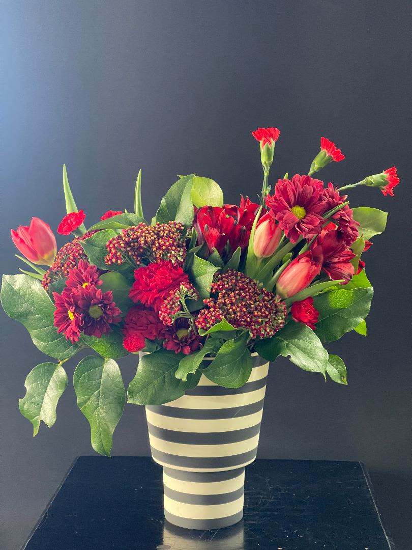 Red and pink mixed bouquet in a striped vase