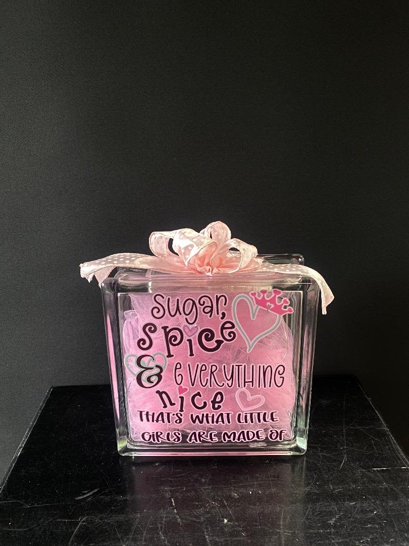 Pink gift box with a ribbon and the words "Sugar, spice &amp; everything nice"
