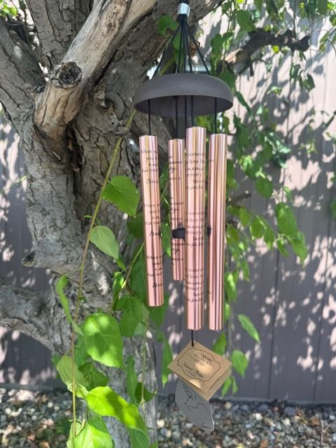 Rose-gold wind chime hanging from a tree branch