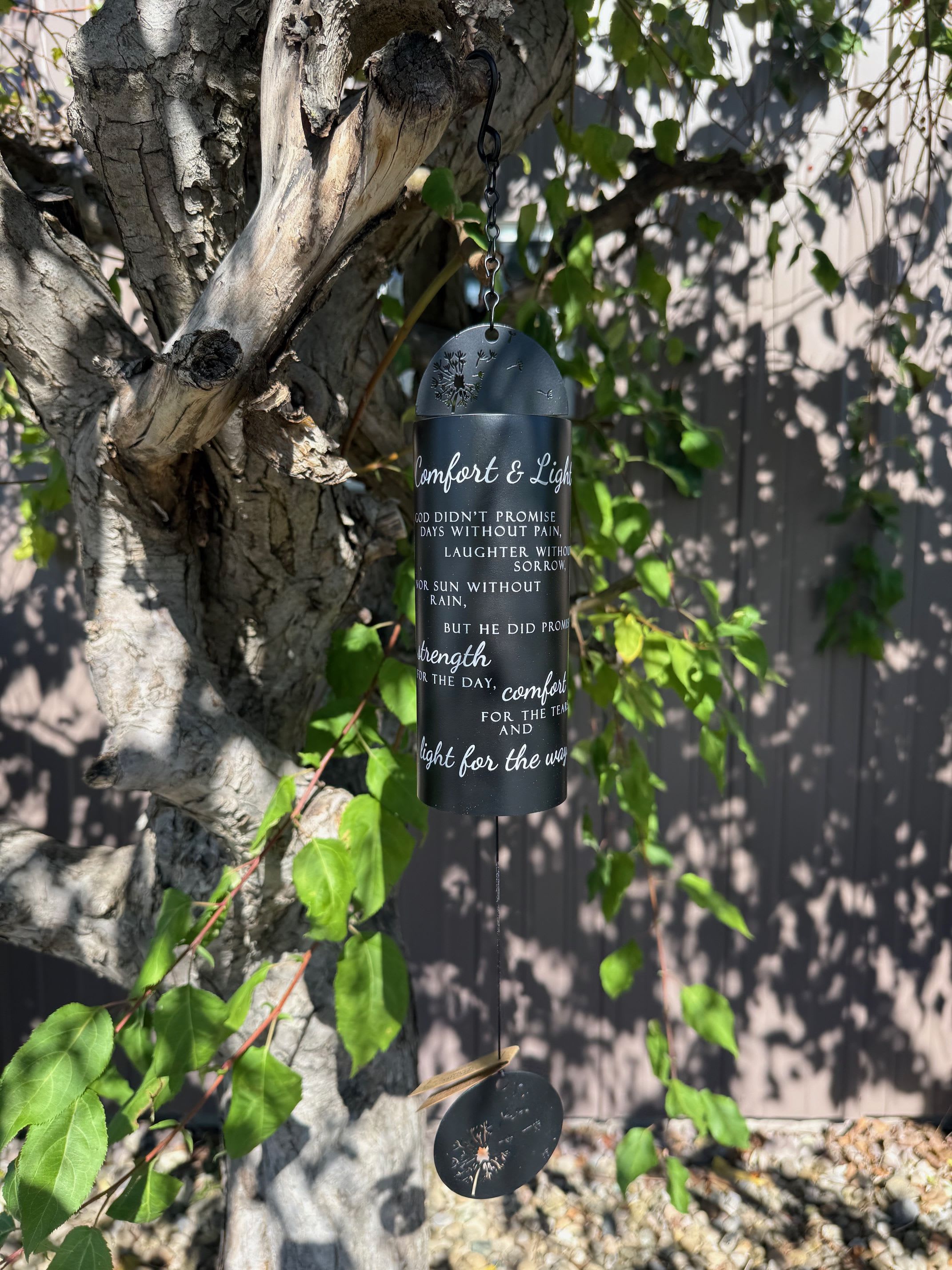 Black memorial wind chime hanging from a tree