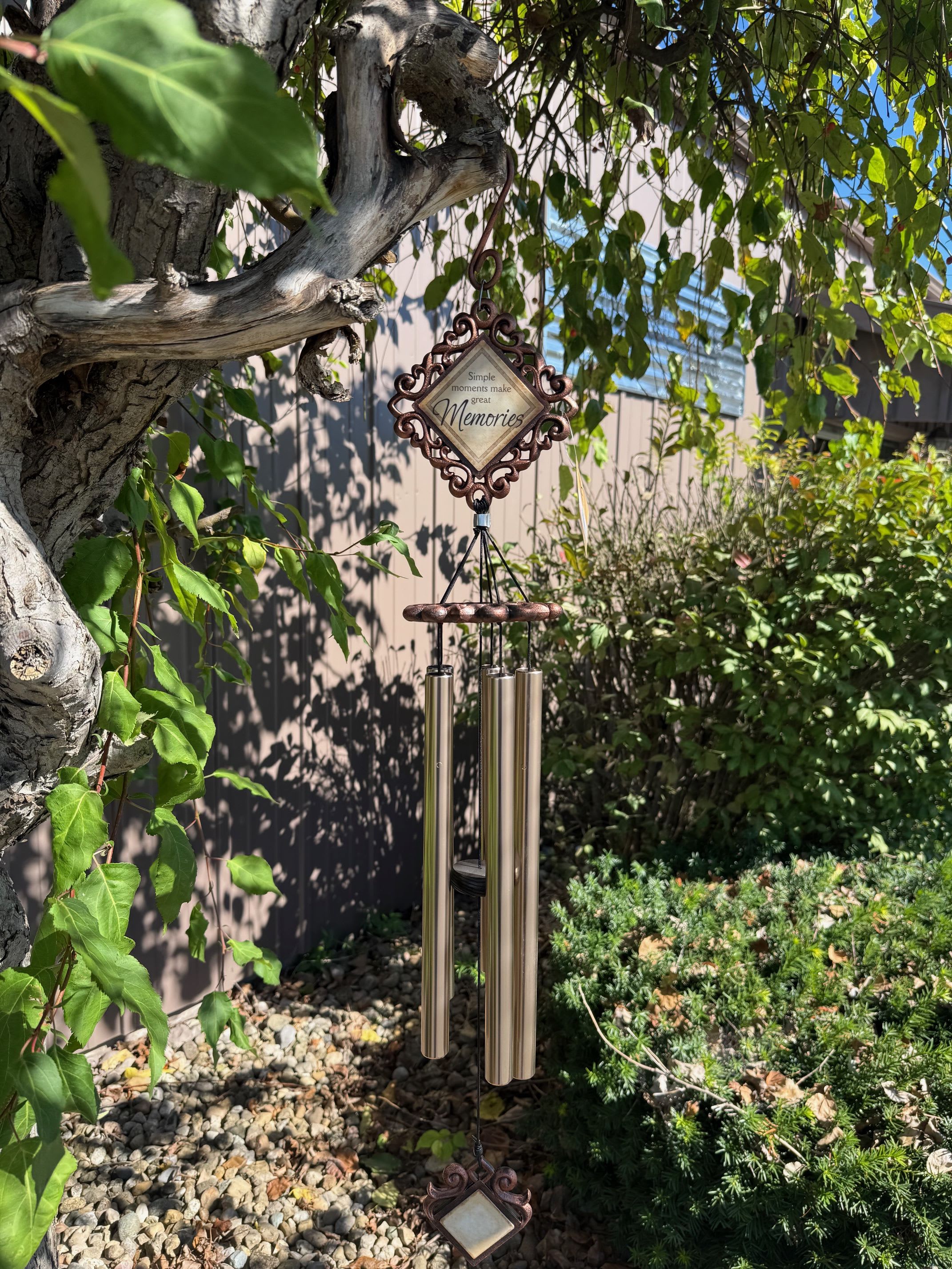 Decorative wind chime hanging from a tree in a garden