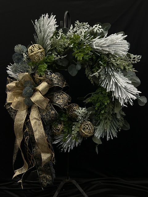 Holiday wreath with silver accents, gold ribbon, and dark greenery