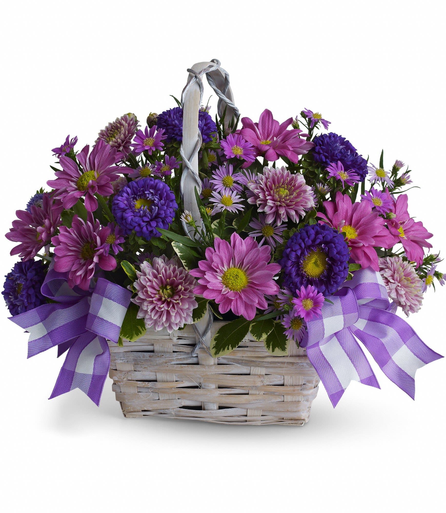 Purple and pink daisy bouquet in a white wicker basket with ribbon bows