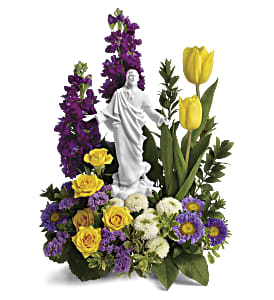 Floral arrangement with a white statue centerpiece, yellow tulips, and purple flowers