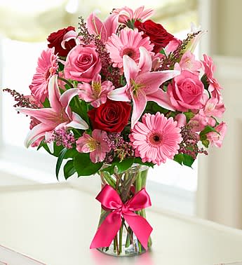 Fields of Europe Romance - At the heart of every great European city is a flourishing flower market. With gorgeous red and pink roses, lilies, Gerbera daisies and alstroemeria, this "field-gathered" bouquet in a glass vase with satin ribbon is a romantic taste of an old-world tradition.