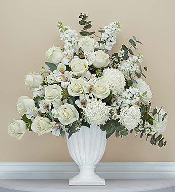 White rose arrangement in a white urn vase