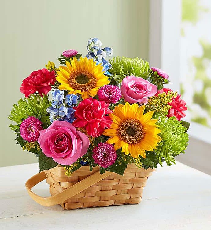 Basket arrangement with sunflowers, pink roses, and mixed blooms