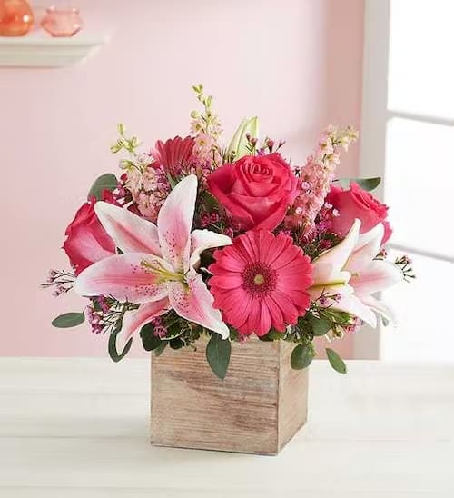 Pink and white flower arrangement in a wooden box