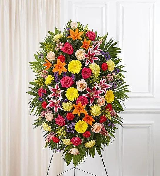 Standing floral spray with roses, lilies, and chrysanthemums on an easel
