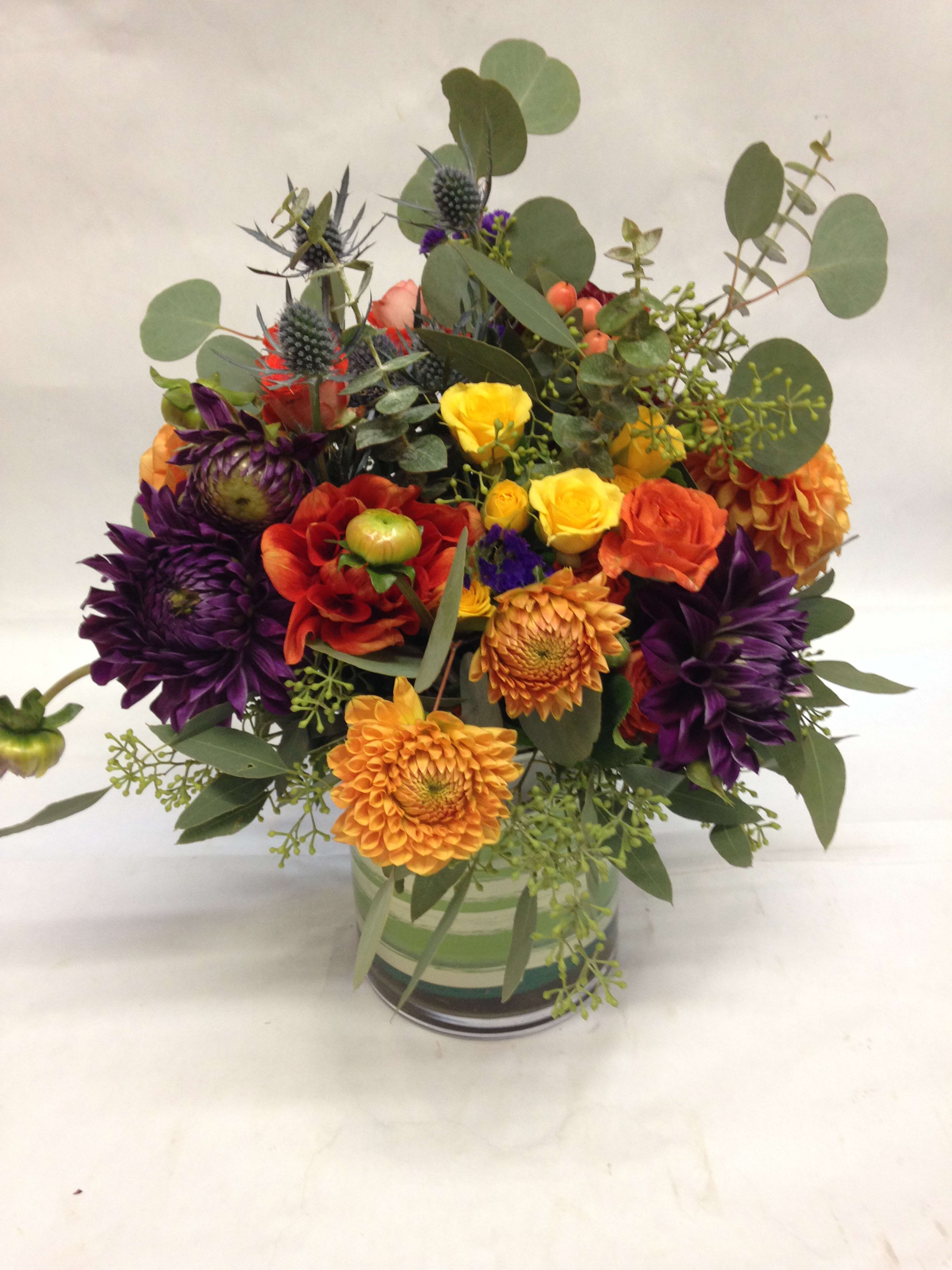 Modern and Fabulous Dahlia Arrangement - This bright and colorful arrangement comes complete with a variety of different dahlias, spray roses, hypericum, sea thistle and various types of eucalyptus.  (Some flowers may be subject to change depending on the season. We will contact you with available flower substitutions; please contact us with specific questions if you are concerned with flower availability, thanks!)  Featured arrangement: $155.00 (Regular Price)