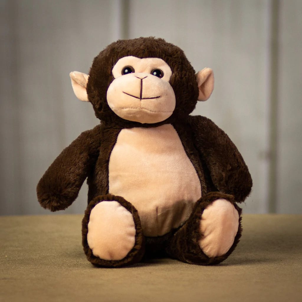 Brown and beige plush monkey toy seated on a neutral surface
