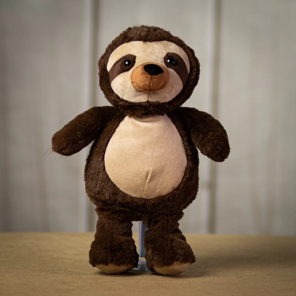Brown and cream sloth plush toy standing upright on a neutral surface