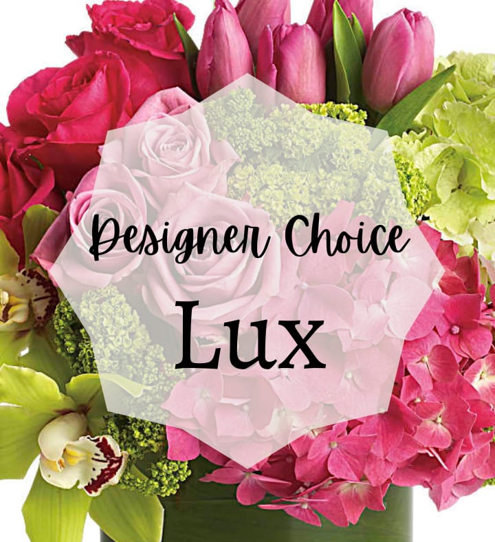 Lush pink and green flower arrangement with roses, tulips, orchids, and hydrangeas in a green vase