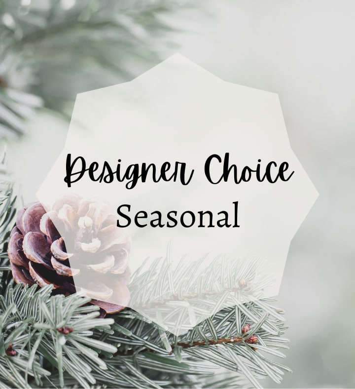 White tag reading Designer Choice Seasonal over pine branches and a pinecone
