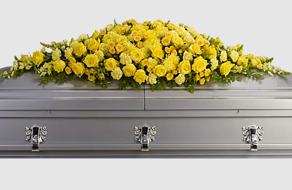 Yellow floral spray on a silver casket