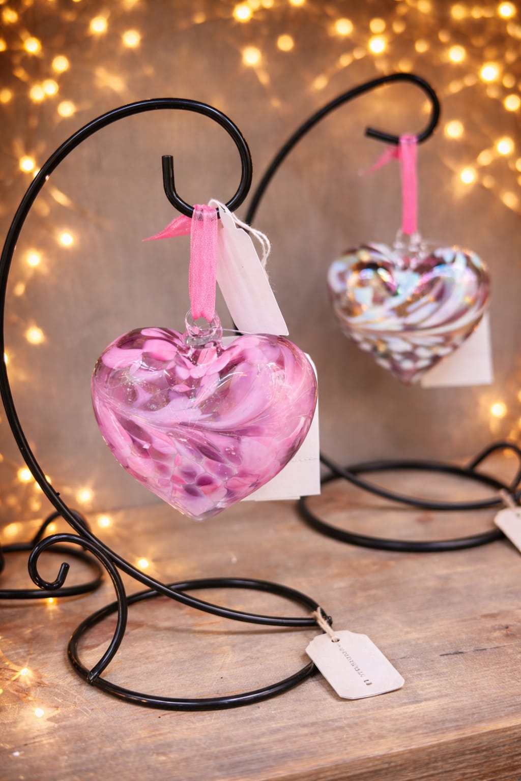 Blown Glass Heart On a Stand - Delicate, meaningful, and beautifully crafted, this small glass heart ornament is a timeless piece designed to be cherished. Each heart is hand-blown, featuring soft swirls of color and subtle shimmer that make every piece truly one of a kind. Displayed on an elegant metal stand, it’s perfect for adding a gentle touch of beauty to any space. This piece makes a heartfelt gift for loved ones or a comforting keepsake for memorials and funerals. The heart shape symbolizes love, remembrance, and connection—making it a thoughtful way to honor someone special or celebrate meaningful moments.  Features: Handcrafted glass with unique color patterns Small, elegant heart design Includes decorative metal stand Perfect for sympathy gifts, memorials, or everyday décor A simple yet powerful symbol of love that can be displayed and treasured for years to come.