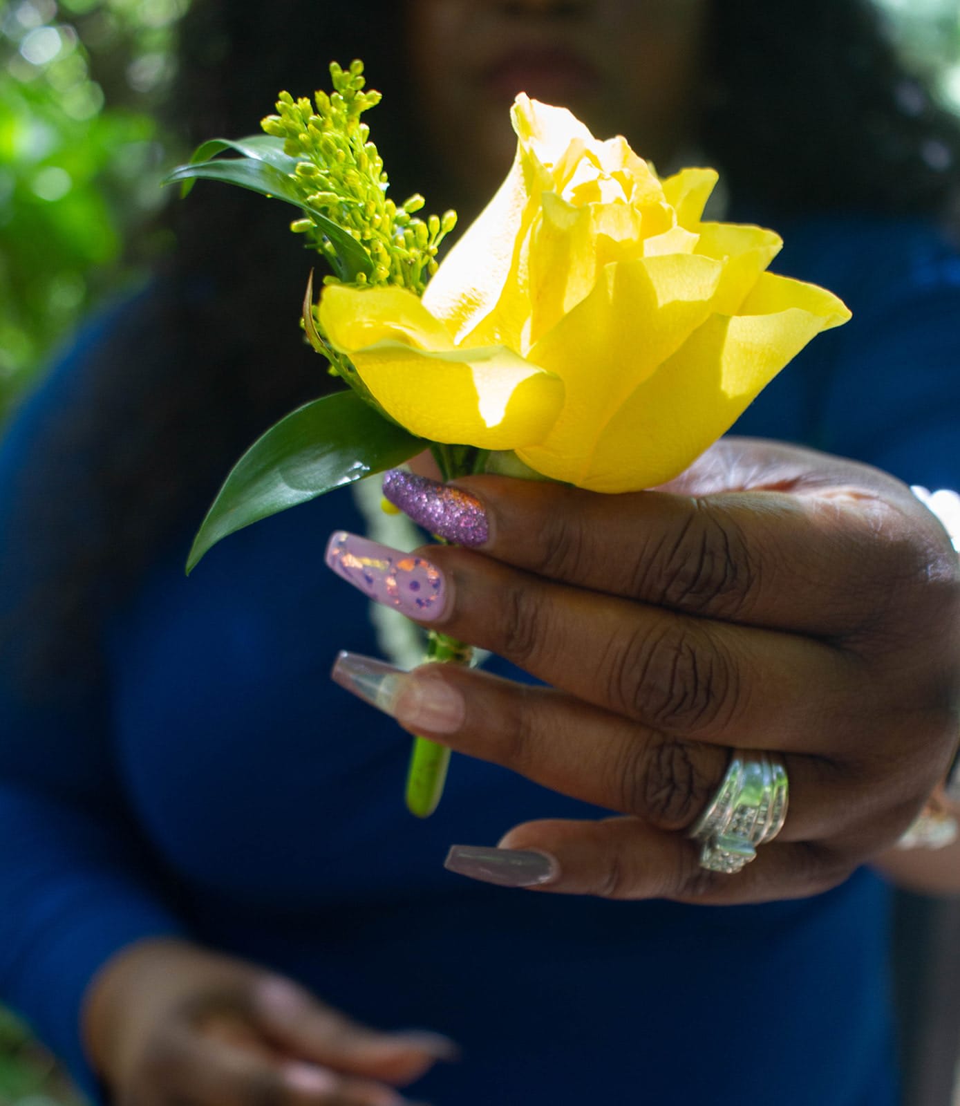Yellow rose boutonniere held in a hand