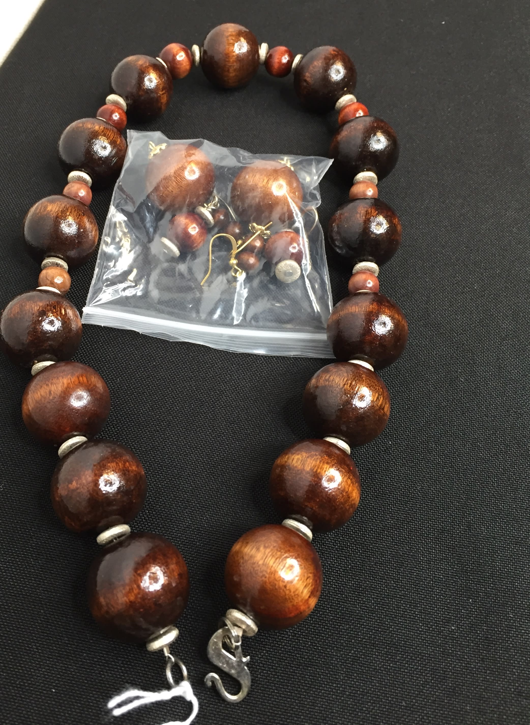 Wood bead necklace with matching earrings in a plastic bag