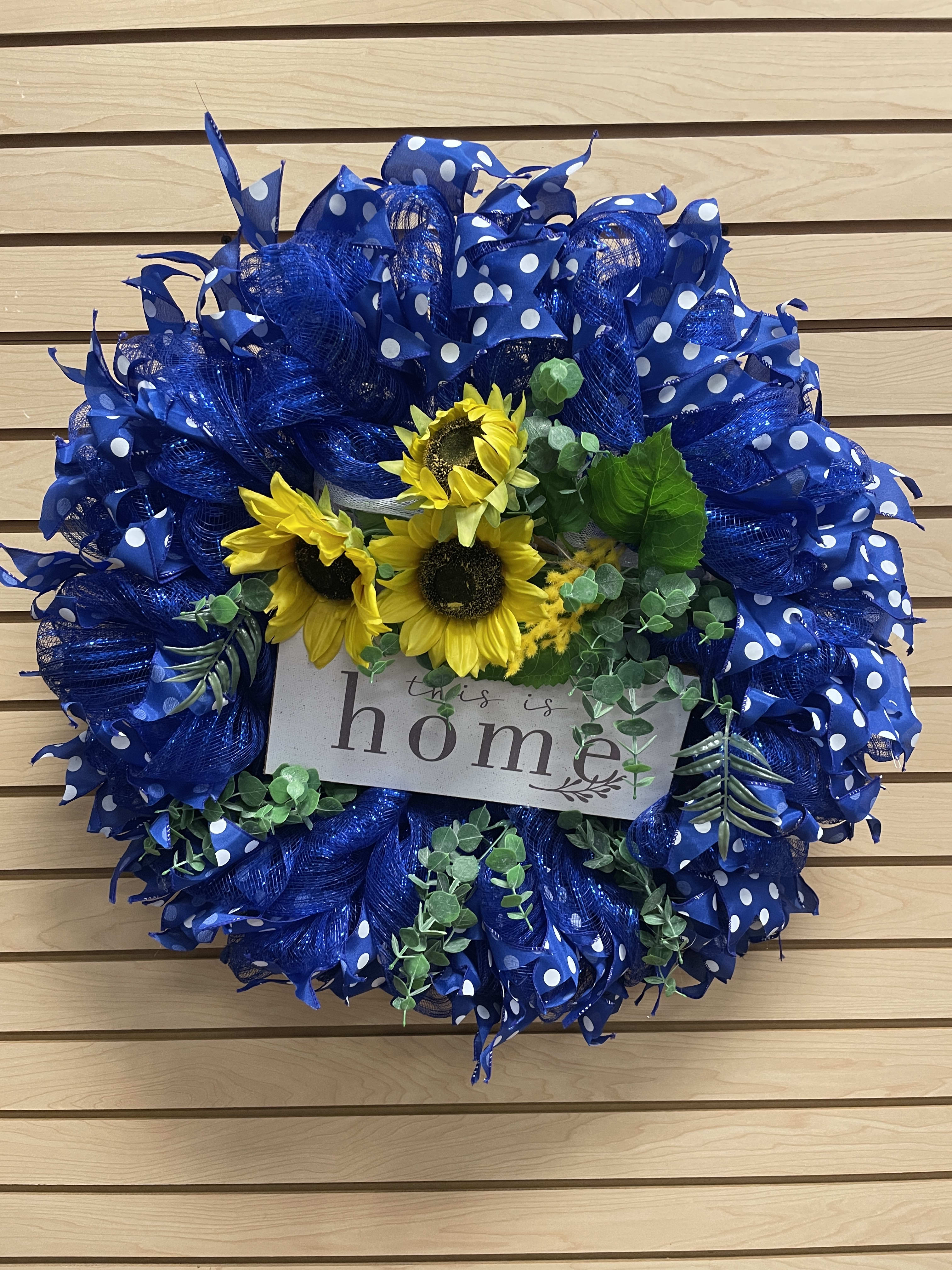 Blue polka-dot wreath with sunflowers and a "this is home" sign