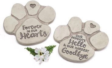Two paw-print memorial stones with a small white flower accent