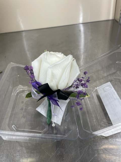 White rose boutonniere with purple accents and ribbon