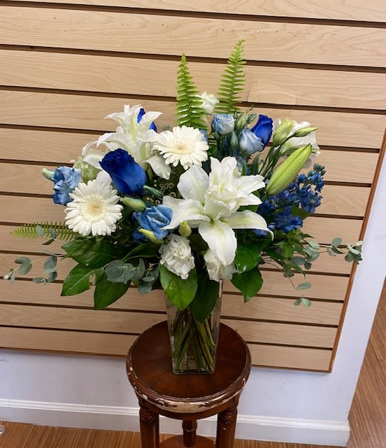 Blue and white floral arrangement in a clear glass vase