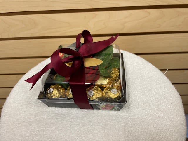 Gift box of chocolates tied with a burgundy ribbon