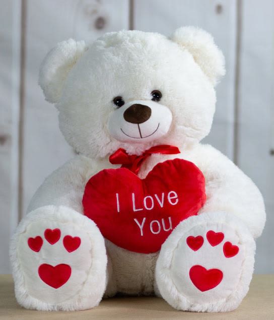 White teddy bear holding a red heart that says I Love You