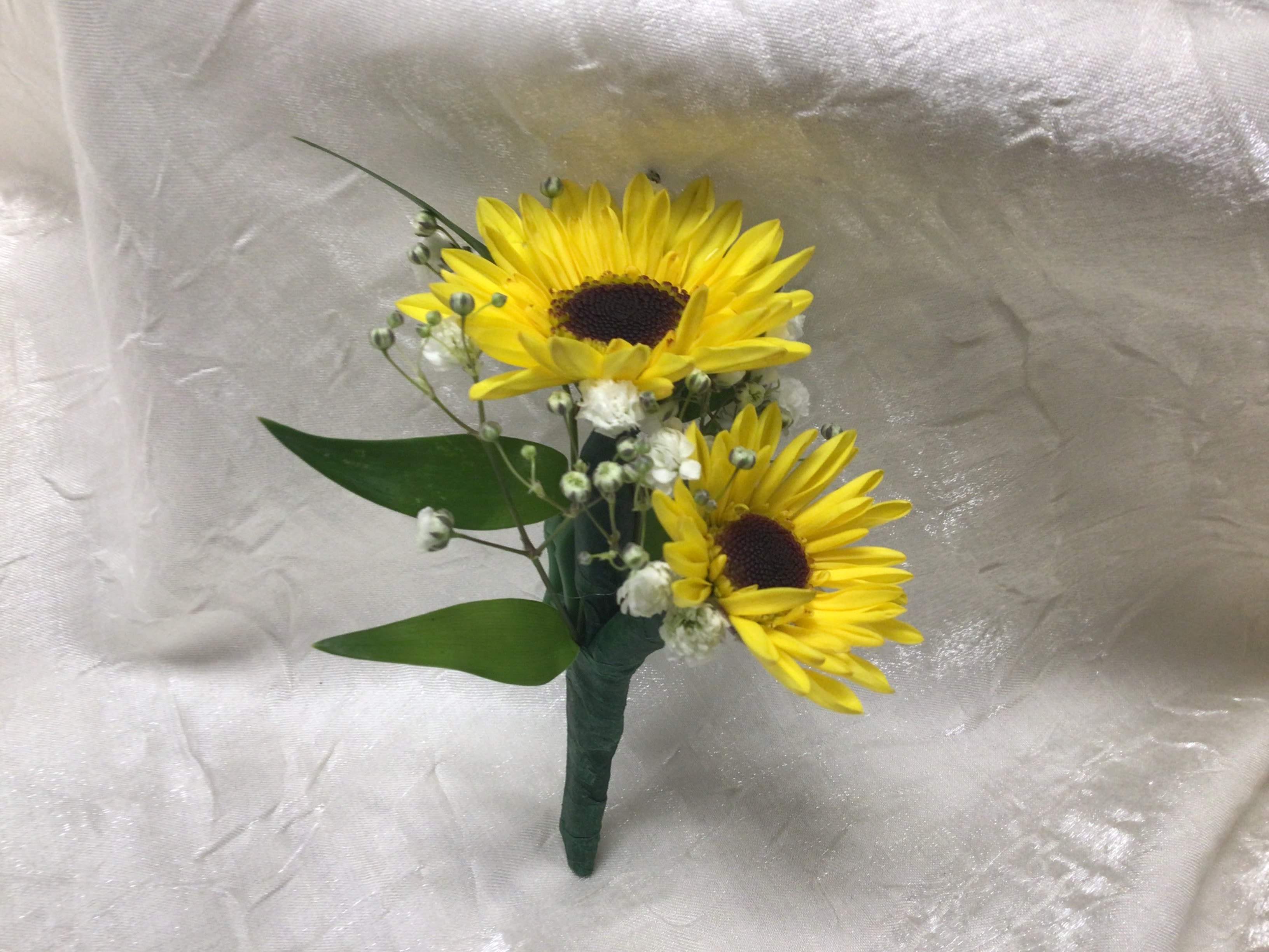 Two yellow sunflowers with small white filler flowers