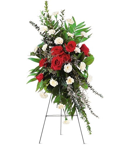 Standing floral spray with red roses and white carnations on an easel