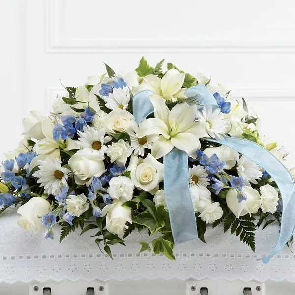 White and blue floral arrangement with a light blue ribbon