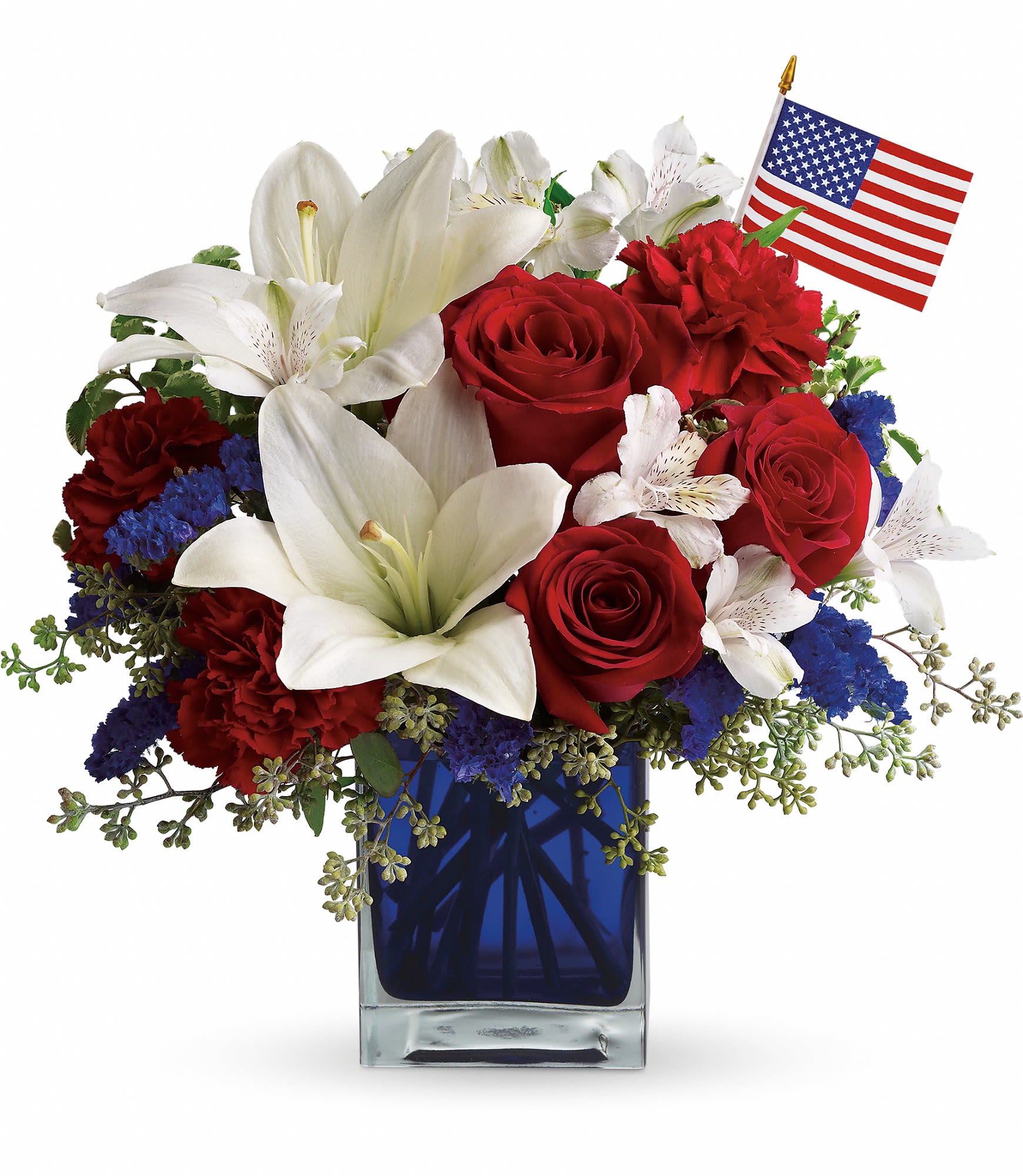 Patriotic Arrangement - This patriotic arrangement is such a stunning way to honor the courage, the character, the people and the places in this country we call home. Red roses and carnations, white asiatic lilies and alstroemeria, blue statice and an American flag fill an exclusive blue glass cube. It's certain to be appreciated from sea to shining sea  Please Note: The bouquet pictured reflects our original design for this product. While we always try to follow the color palette, we may replace stems to deliver the freshest bouquet possible, and we may sometimes need to use a different vase. 