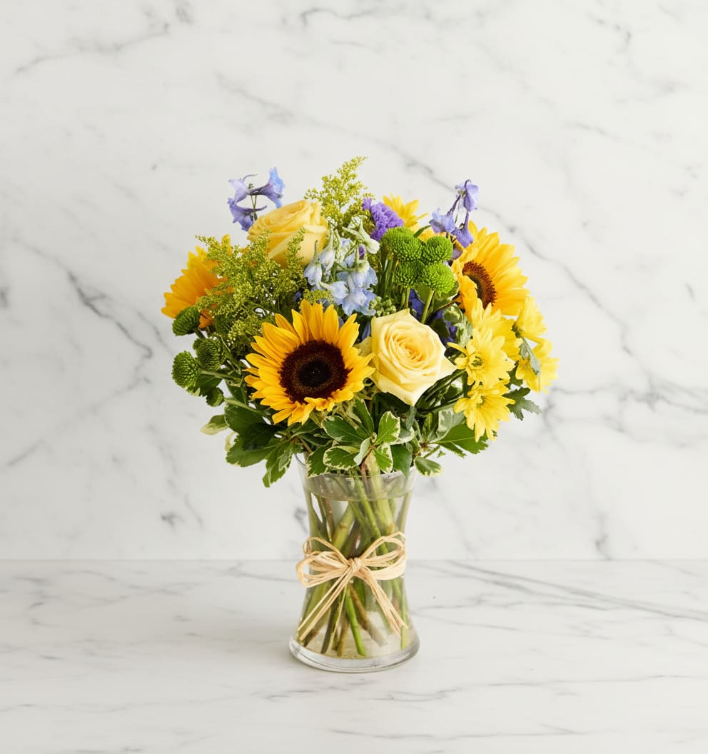 Fields Of Europe-Summer - Inspired by the colorful charm of the European countryside, our best-selling summer bouquet is gathered with fresh-picked blooms, revealing the rustic beauty of nature. Shades of golden yellow and rich blue pop against lush greenery, creating a timeless gift for someone special to enjoy. 