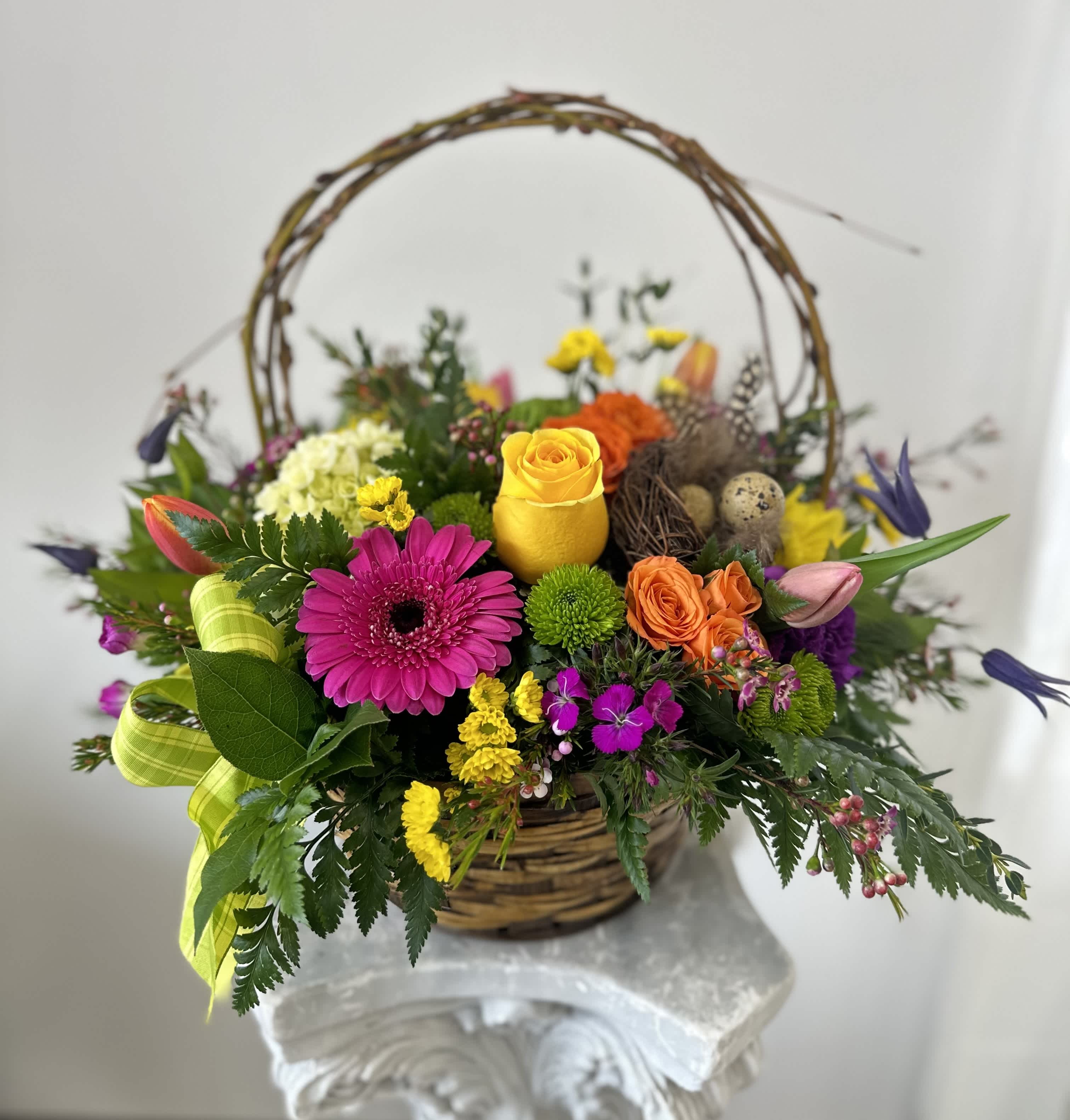 Easter Flower Basket by Westford Florist Art by Veny - Elevate your Easter celebrations with the exquisite Easter Flower Basket by Westford Florist Art by Veny. This stunning floral arrangement is designed to infuse your home with the vibrant essence of spring, making it an ideal centerpiece or a thoughtful gift for loved ones. Delight in the harmonious blend of roses, tulips, gerbera daisies, and more, all arranged on a lush bed of greenery. Each basket is lovingly adorned with real blown quail eggs, adding a unique touch that embodies the spirit of the season. Whether you're enhancing your festive decor or expressing heartfelt sentiments through thoughtful gifting, this Easter Flower Basket promises to bring joy and elegance to any gathering.