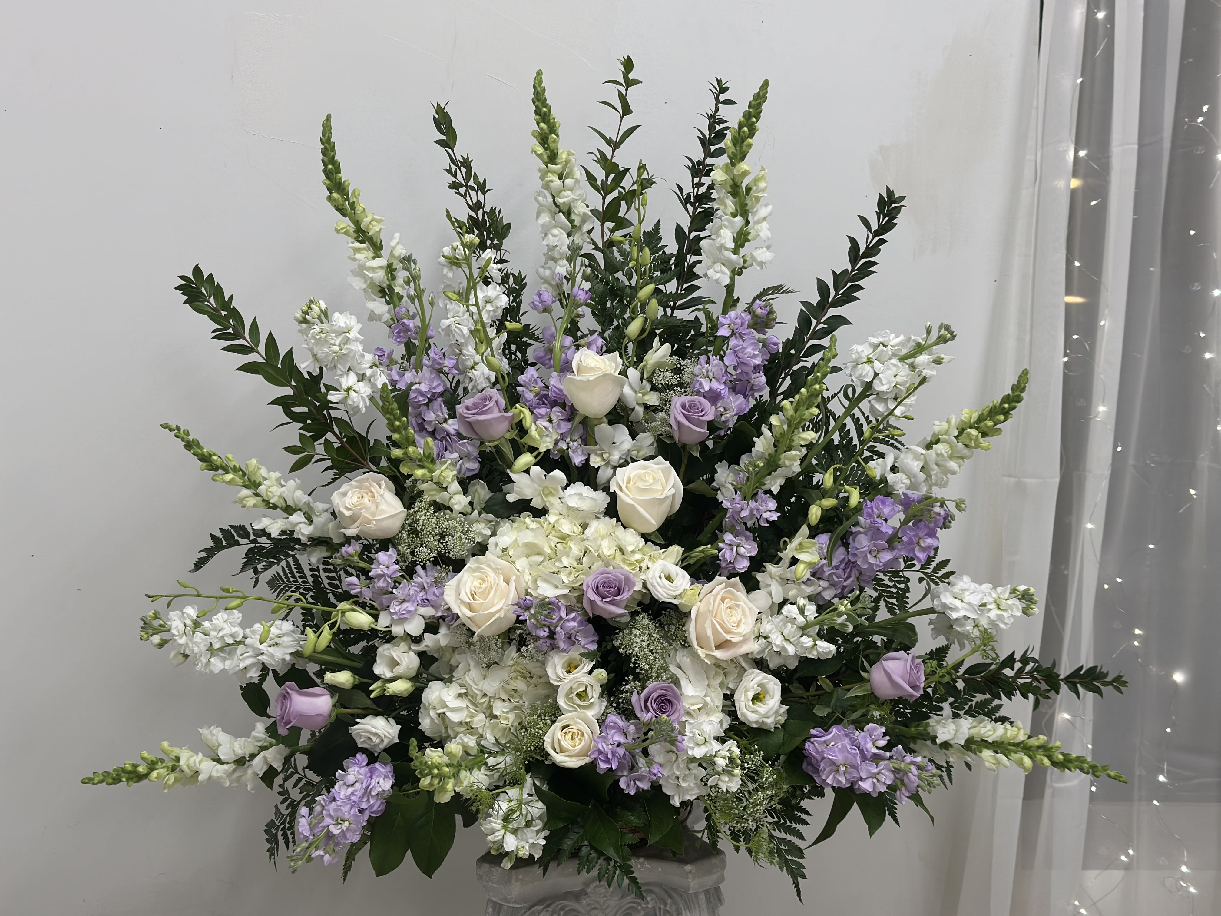 Large white and lavender floral arrangement in a vase