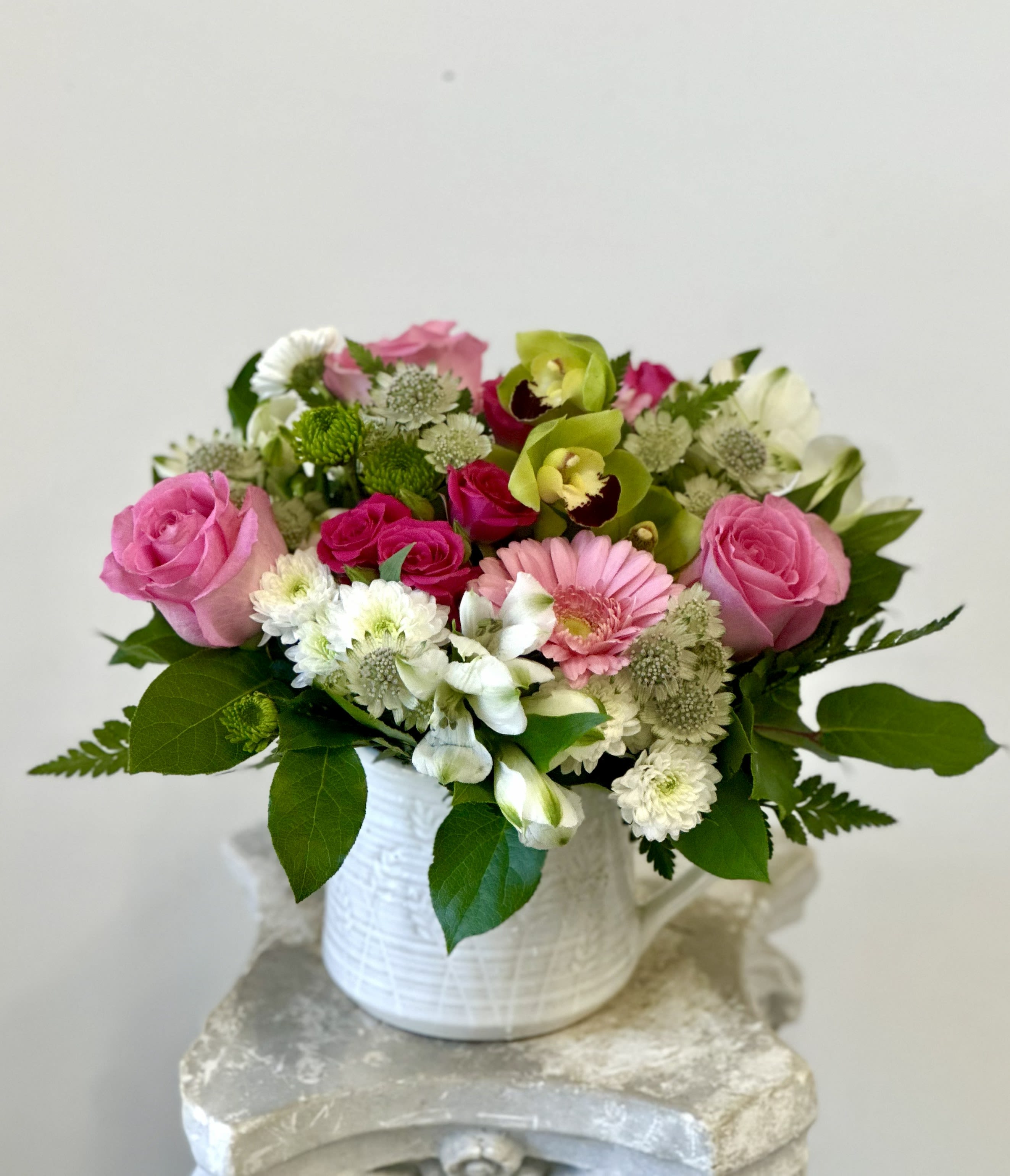 Pink and white mixed flower arrangement in a white vase