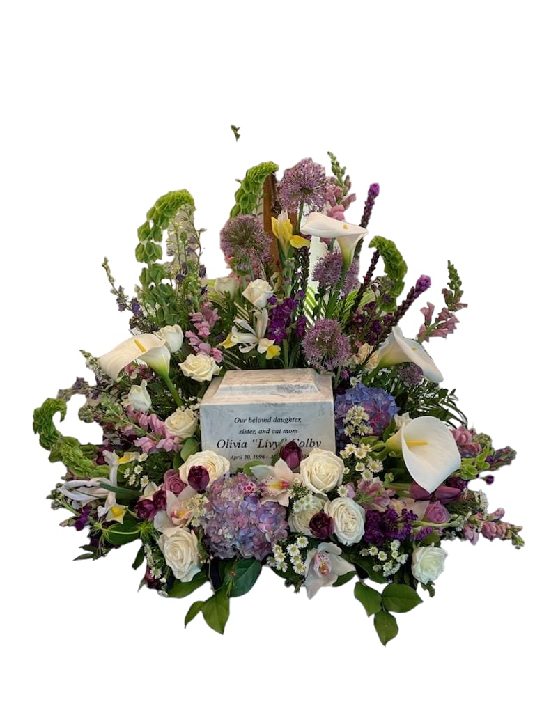 Large sympathy floral arrangement with white calla lilies and roses around an urn
