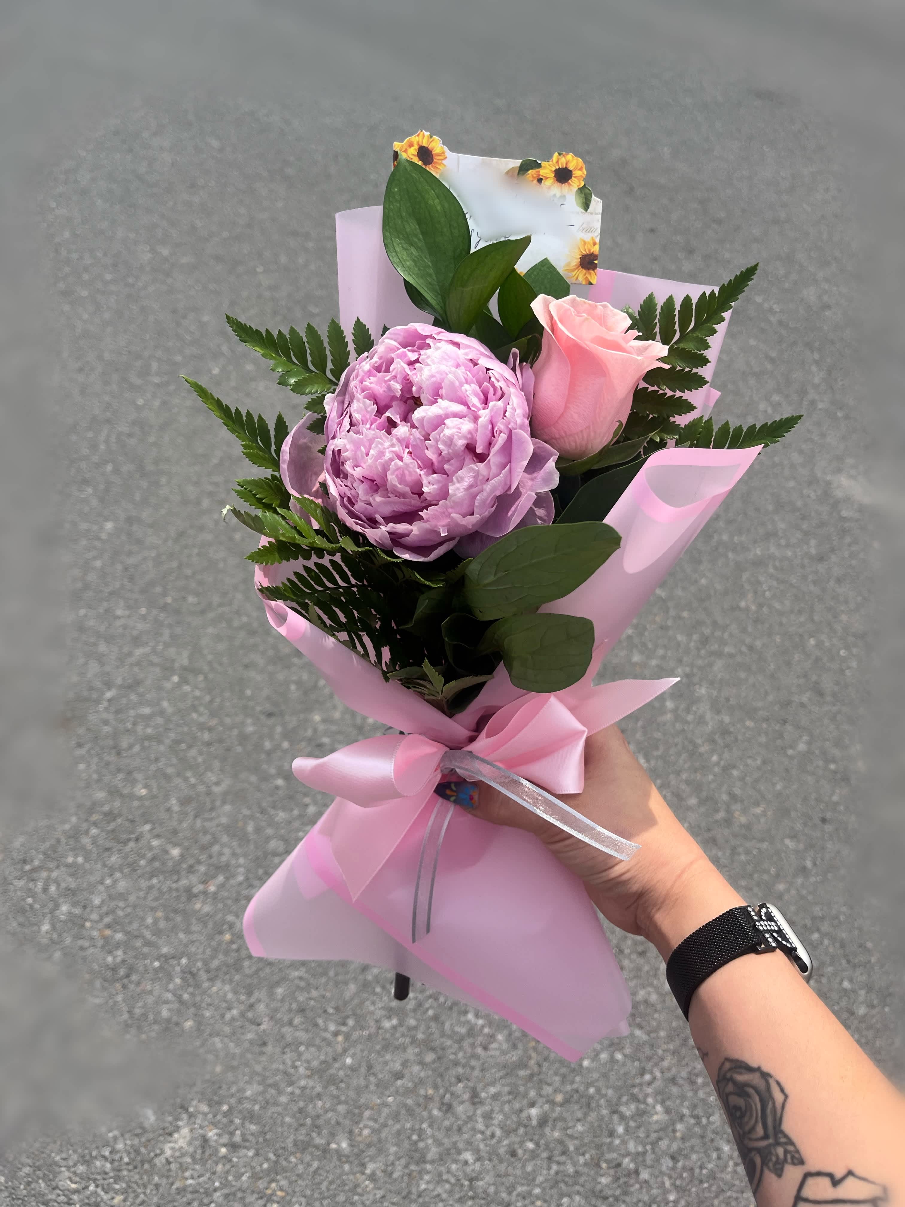 Pink peony and rose bouquet wrapped in pink paper