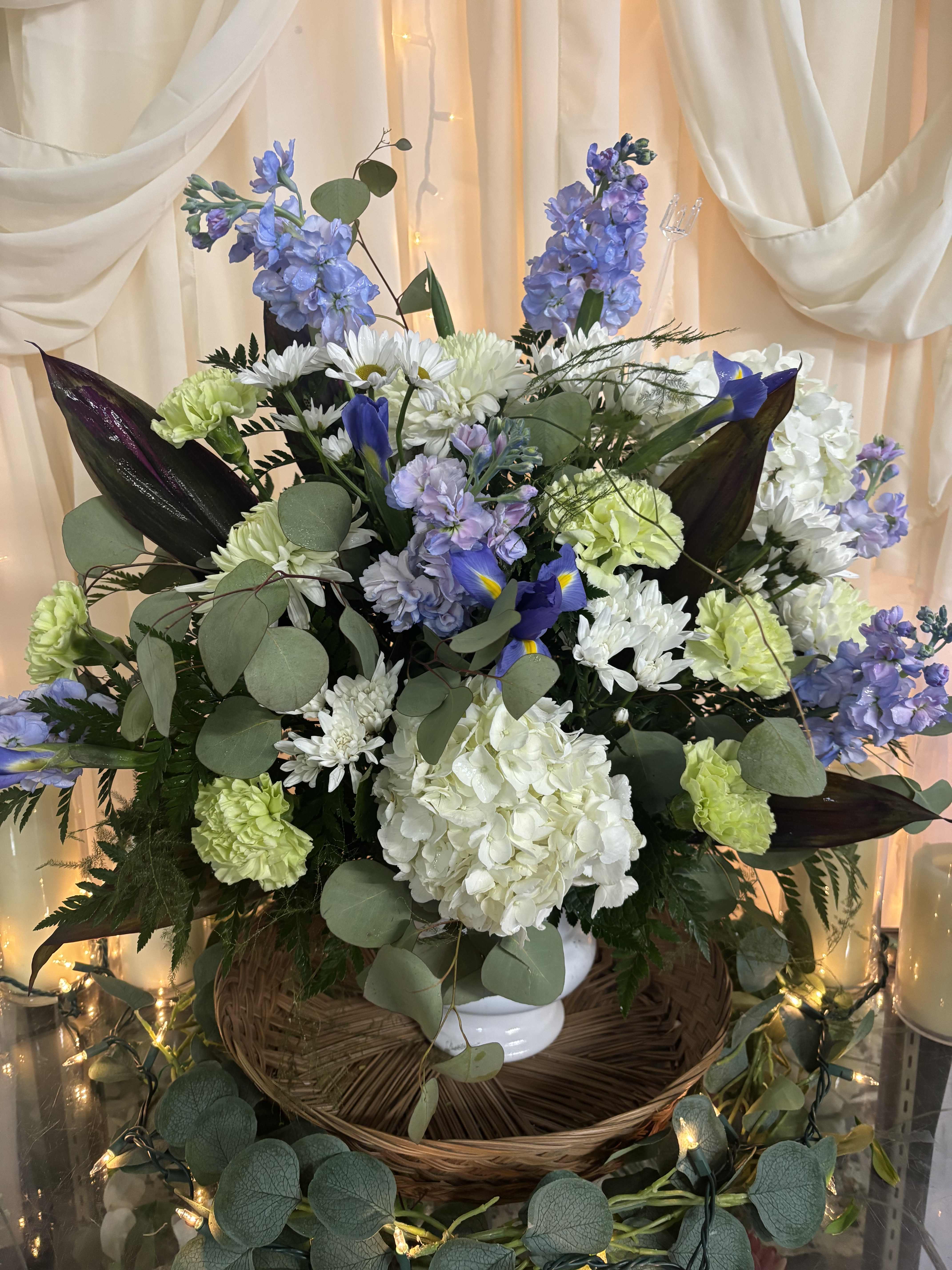 Large bouquet of white, blue, and green flowers in a white vase