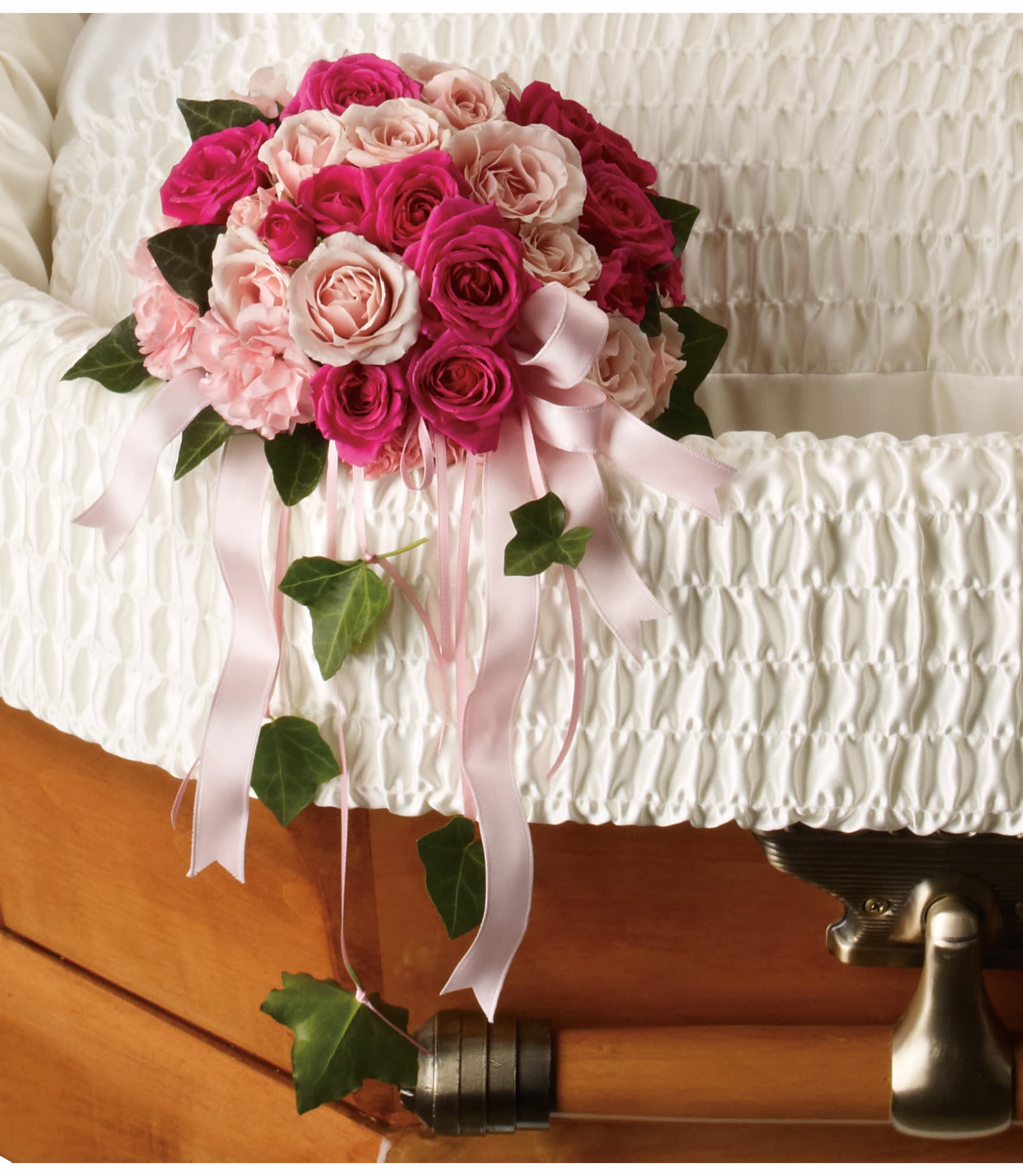 Spray Rose Reflection Casket Cluster - A beautiful gesture, this lovely array of pink spray roses and pink carnations inside the casket inspires a feeling of closeness with the lost loved one. This nosegay or cluster is available in many color and flower combinations.  Please call for details and banner options 