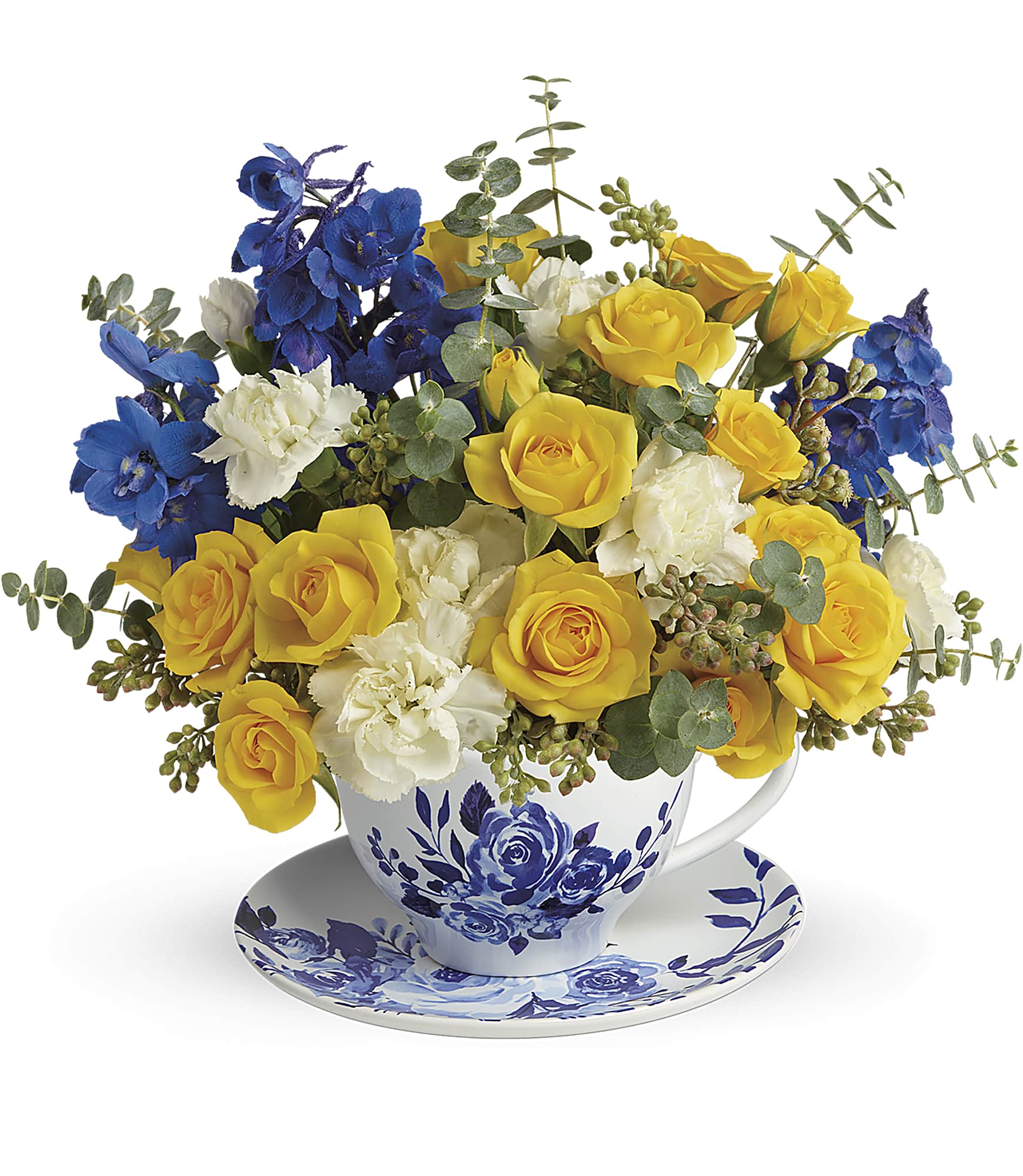 Yellow and blue flower arrangement in a teacup with saucer