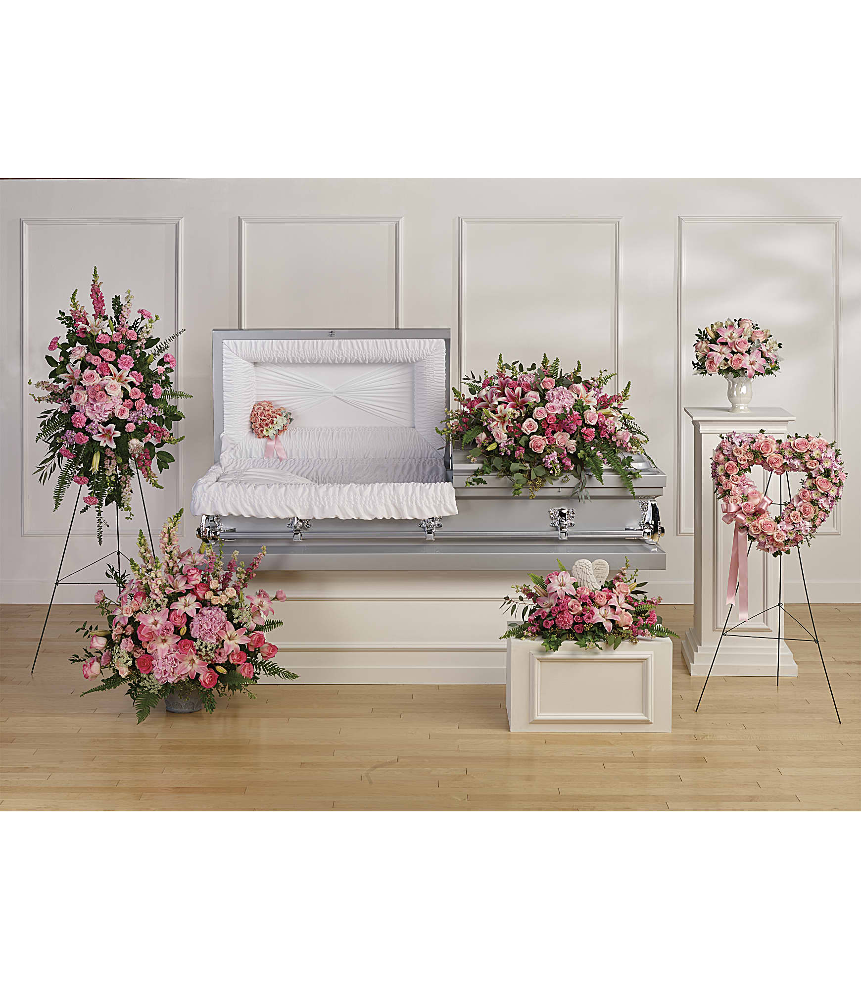 Pink floral funeral casket spray with matching wreaths and arrangements