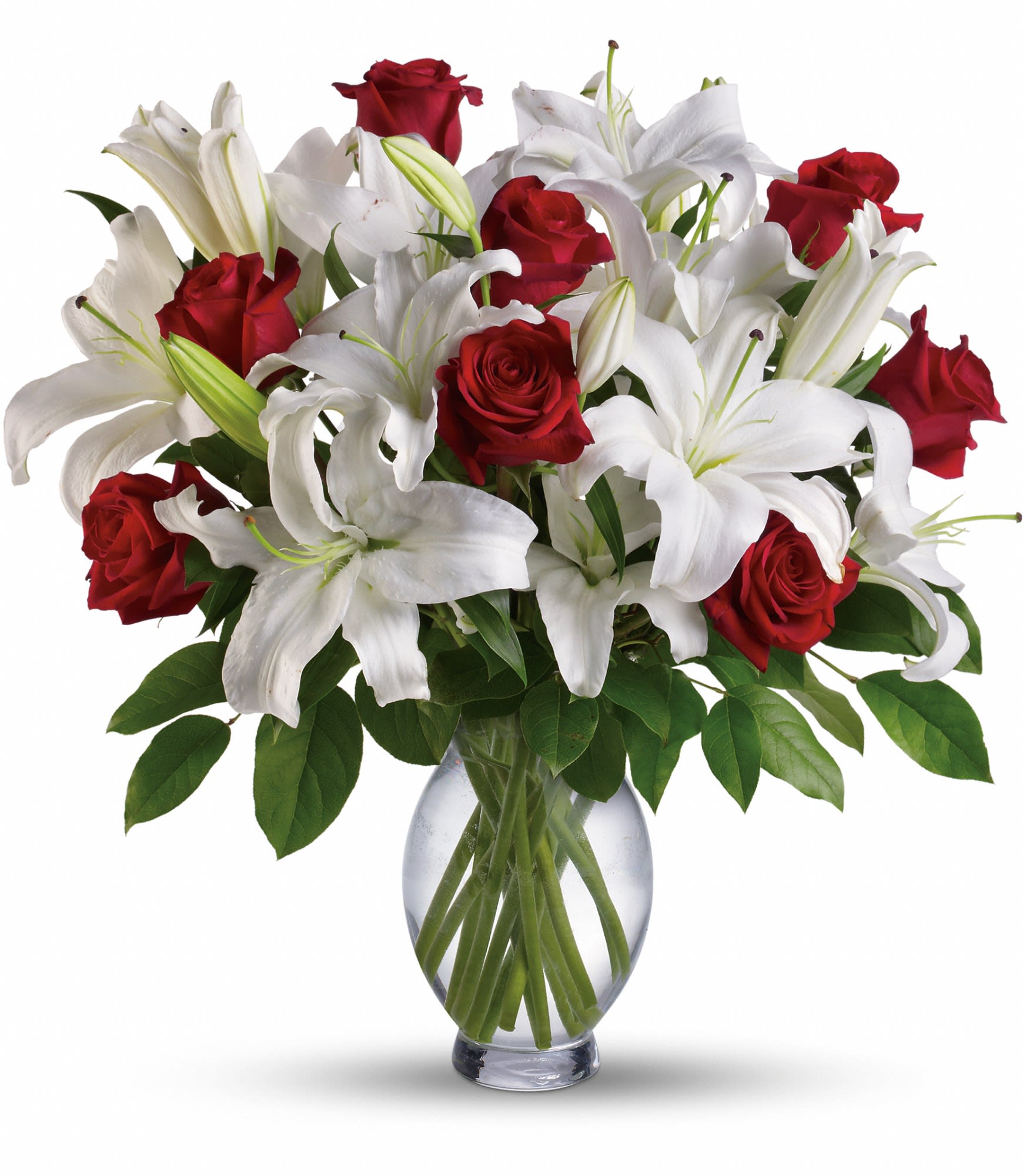 Red roses and white lilies arranged in a clear glass vase