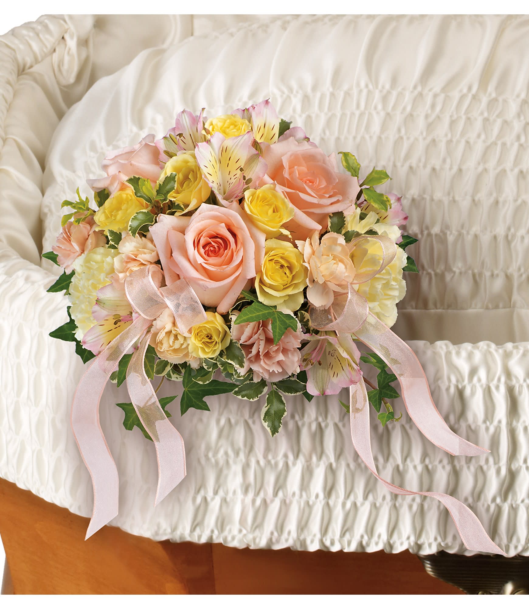 Pastel rose bouquet with ribbon on a white quilted surface