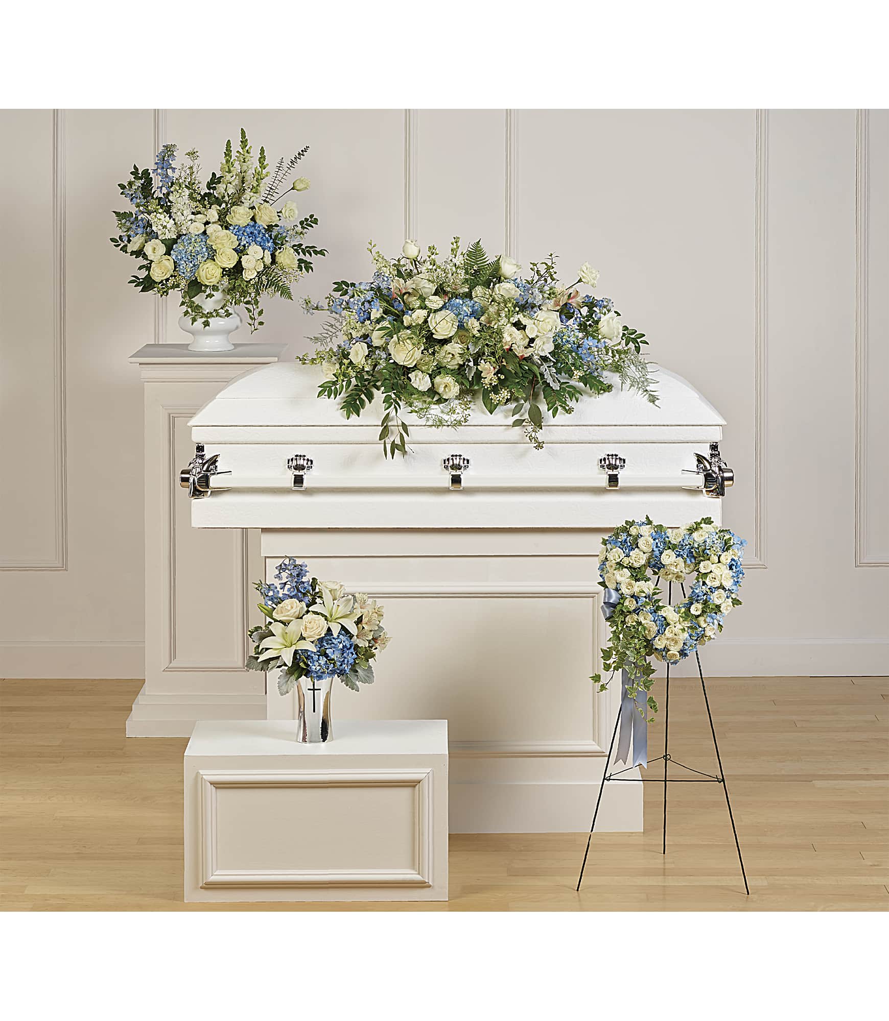 White casket with blue and white floral sprays